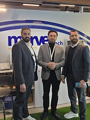 Three men in suits standing in front of a wall with a 'marve' logo at a tech event.