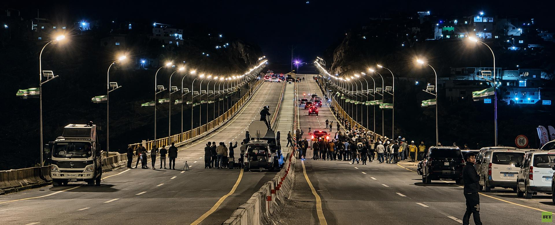 Vehicles and people on Al-Rastan bridge on the evening of its reopening